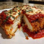 A cross-section view of Easy Chicken Parmesan showing juicy white meat, crispy breading, marinara sauce, and melted mozzarella.