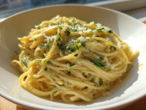 A close-up of a bowl filled with bright, creamy lemon pasta, topped with fresh parsley and grated cheese.