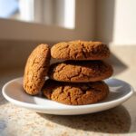 A stack of three amazingly soft gingerbread cookies, coated in sugar crystals, resting on a small white plate.