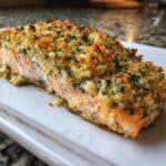 Close-up of a perfectly baked stuffed salmon fillet with a golden, herbed breadcrumb crust.