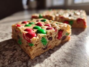 Close-up of a chewy Christmas cookie bars square topped with red and green M&M's.