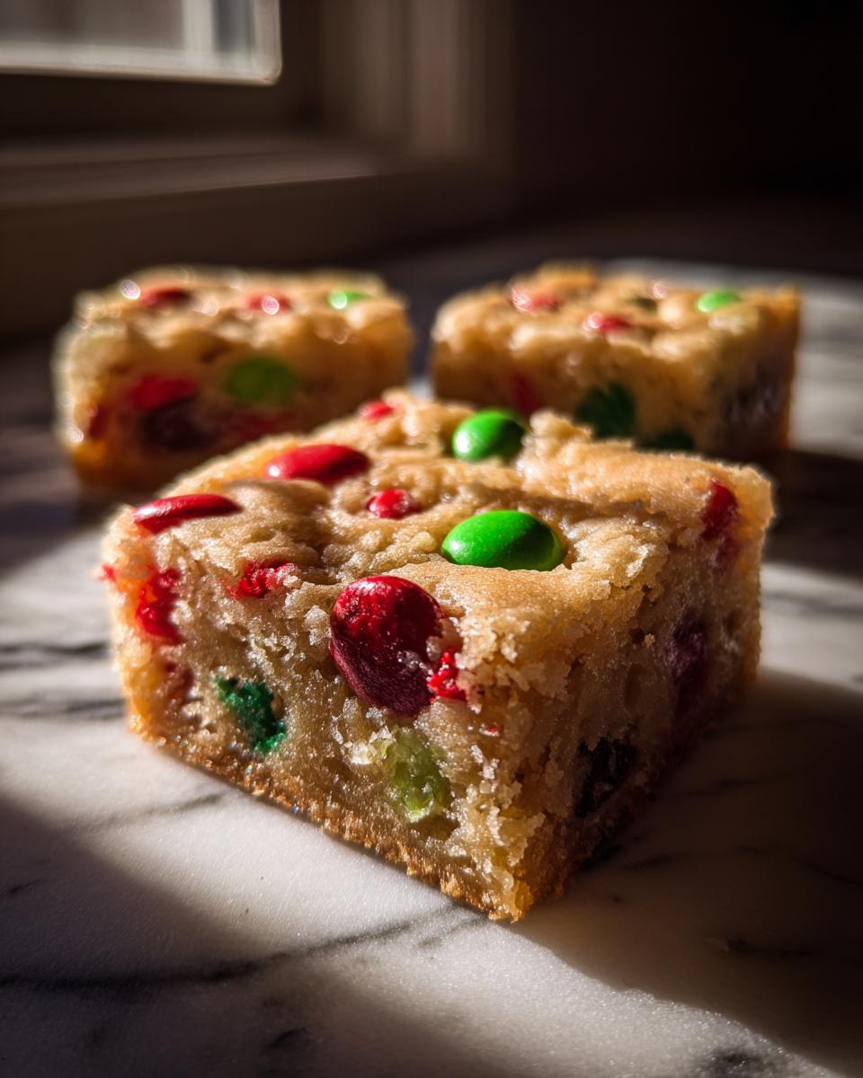 Close-up of a chewy Christmas cookie bars square topped with red and green M&Ms.