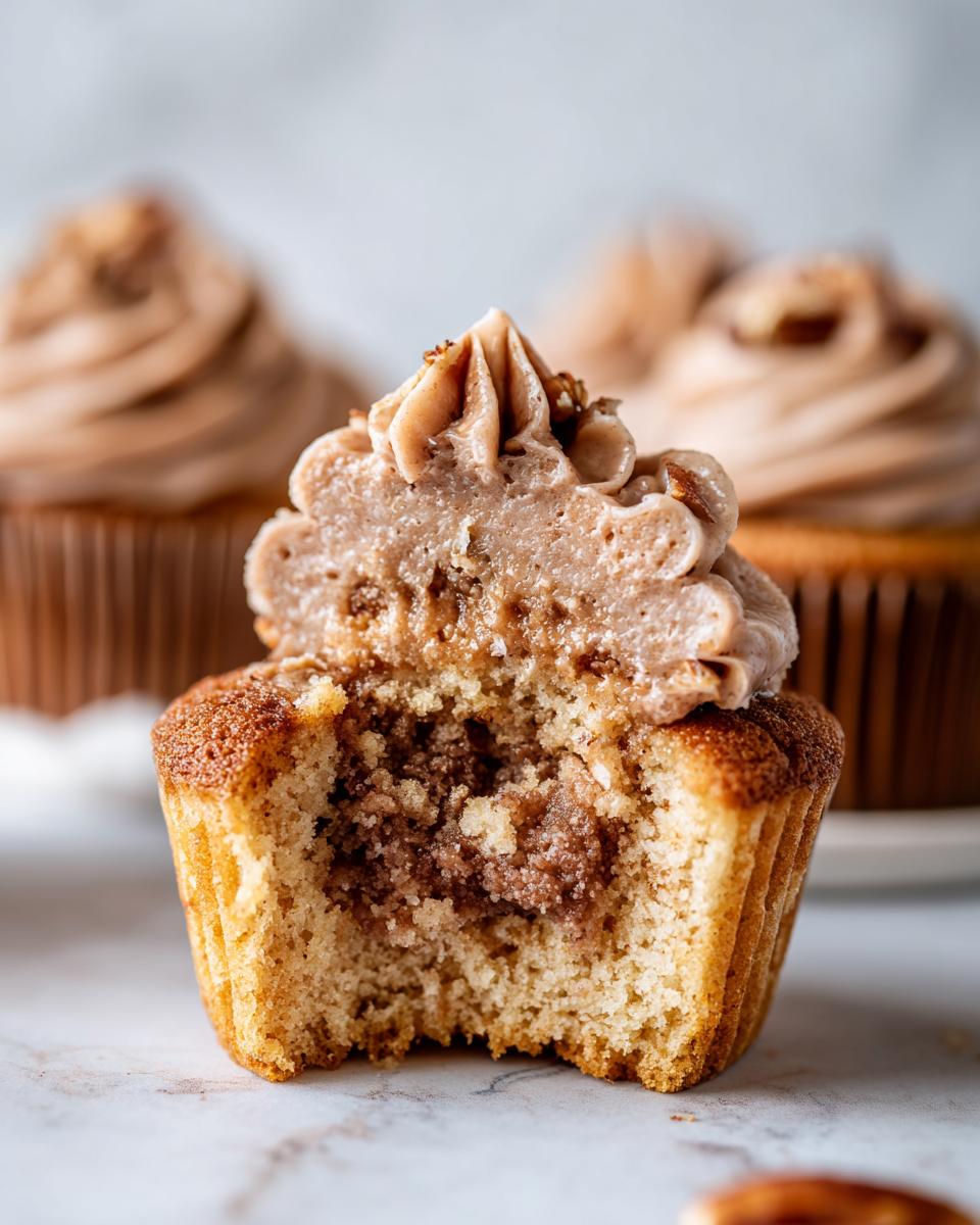 Close-up of a pecan pie cupcakes cut in half showing the filling and pecan frosting.