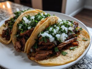 Close-up of three street-style steak tacos filled with shredded meat and topped generously with diced white onion and cilantro.