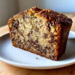 Close-up of a moist slice of chocolate chip banana bread showing dense crumb and melted chocolate chips.