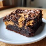 A rich, fudgy square of peanut butter swirl brownies served on a small white plate.