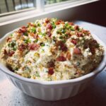 A creamy, loaded 5-minute million dollar dip topped generously with bacon bits and chopped chives.