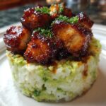 Close-up of honey lime chicken & avocado rice stack, featuring glazed chicken pieces atop molded rice mixed with avocado.