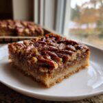 Close-up of a rich, gooey keto pecan square recipe slice on a white plate.