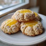 A stack of four delicious lemon lavender thumbprint cookies topped with bright yellow filling and white drizzle.