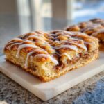 A close-up of a square salted caramel cinnamon sourdough pop tart bar, drizzled with white icing.