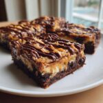 A close-up of rich Samoa box mix brownies topped with toasted coconut, caramel, and a chocolate drizzle.