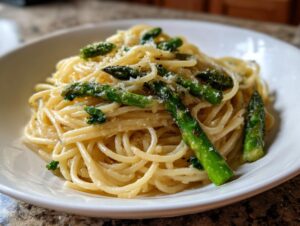 Close-up of a bowl of Lemon Asparagus Pasta tossed with bright green asparagus spears and grated Parmesan.